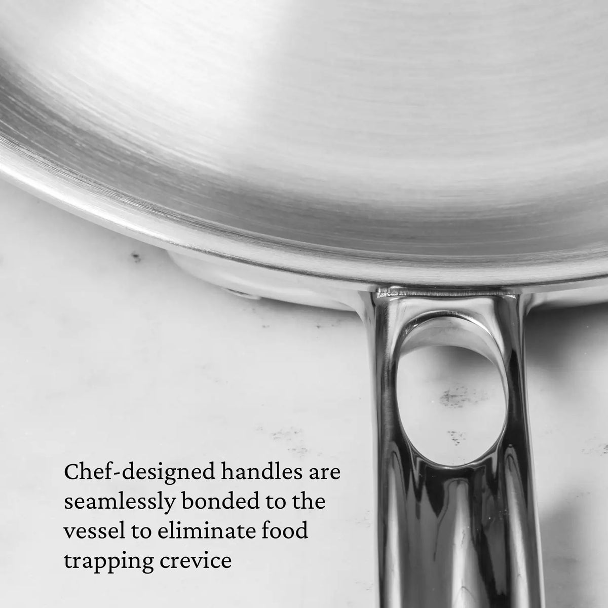 Close-up of a Thomas Keller Commercial Clad Stainless Steel Saucepan handle, seamlessly bonded to the pan for professional performance and easy cleaning with no food-trapping crevices.