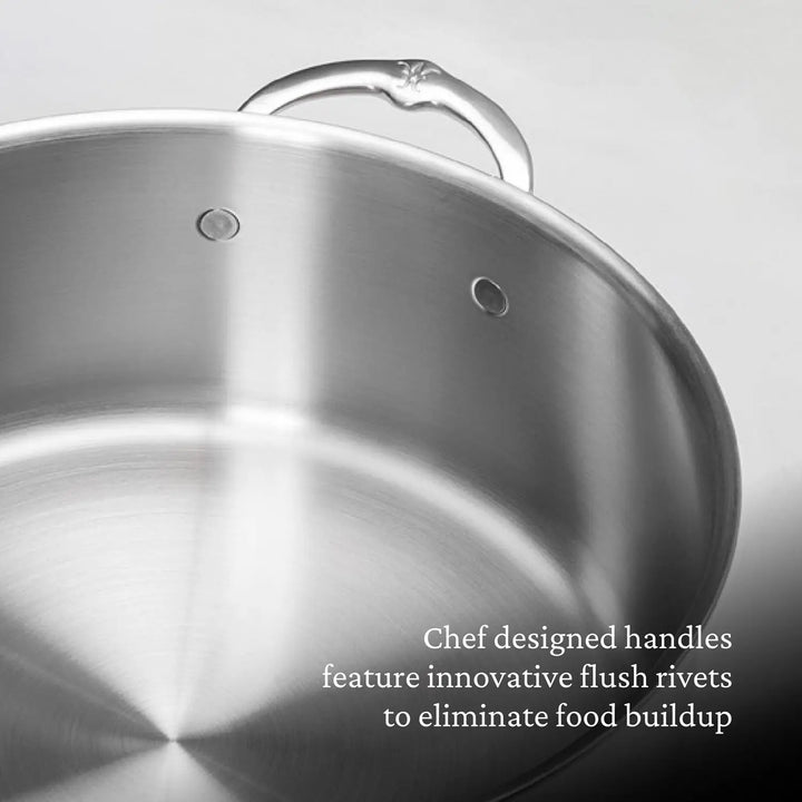 A close-up of the Thomas Keller Commercial Clad Stainless Steel Stock Pot, featuring chef-designed handles with innovative flush rivets to eliminate food buildup.