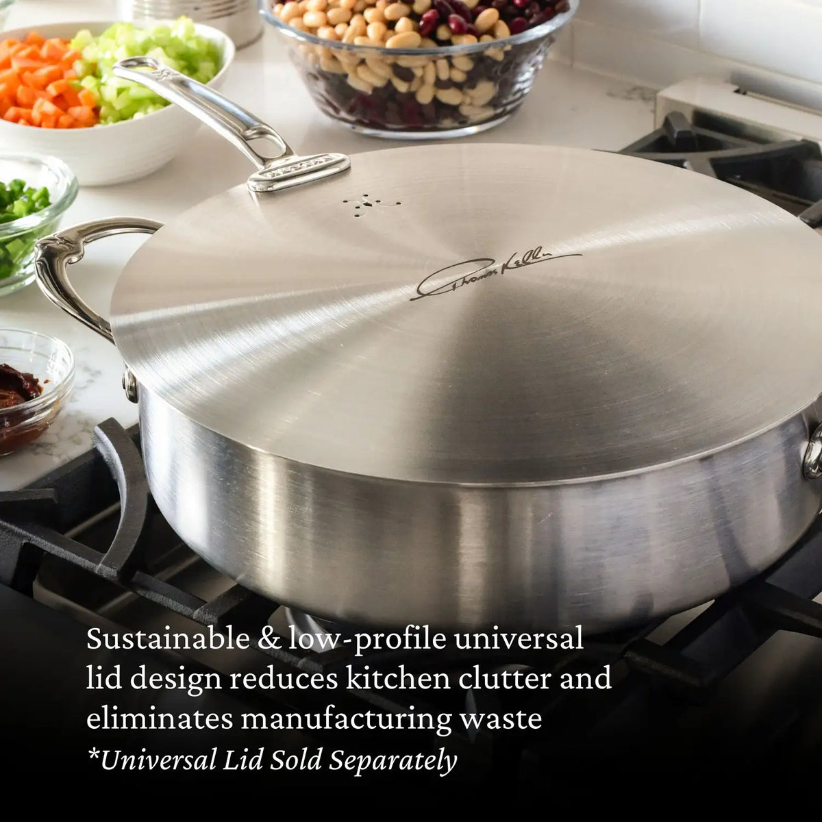 A large Thomas Keller Commercial Clad Stainless Steel Rondeau with a low-profile universal lid—sold separately—sits on a stove, surrounded by bowls of chopped vegetables and beans. The tri-ply clad cookware design is highlighted.