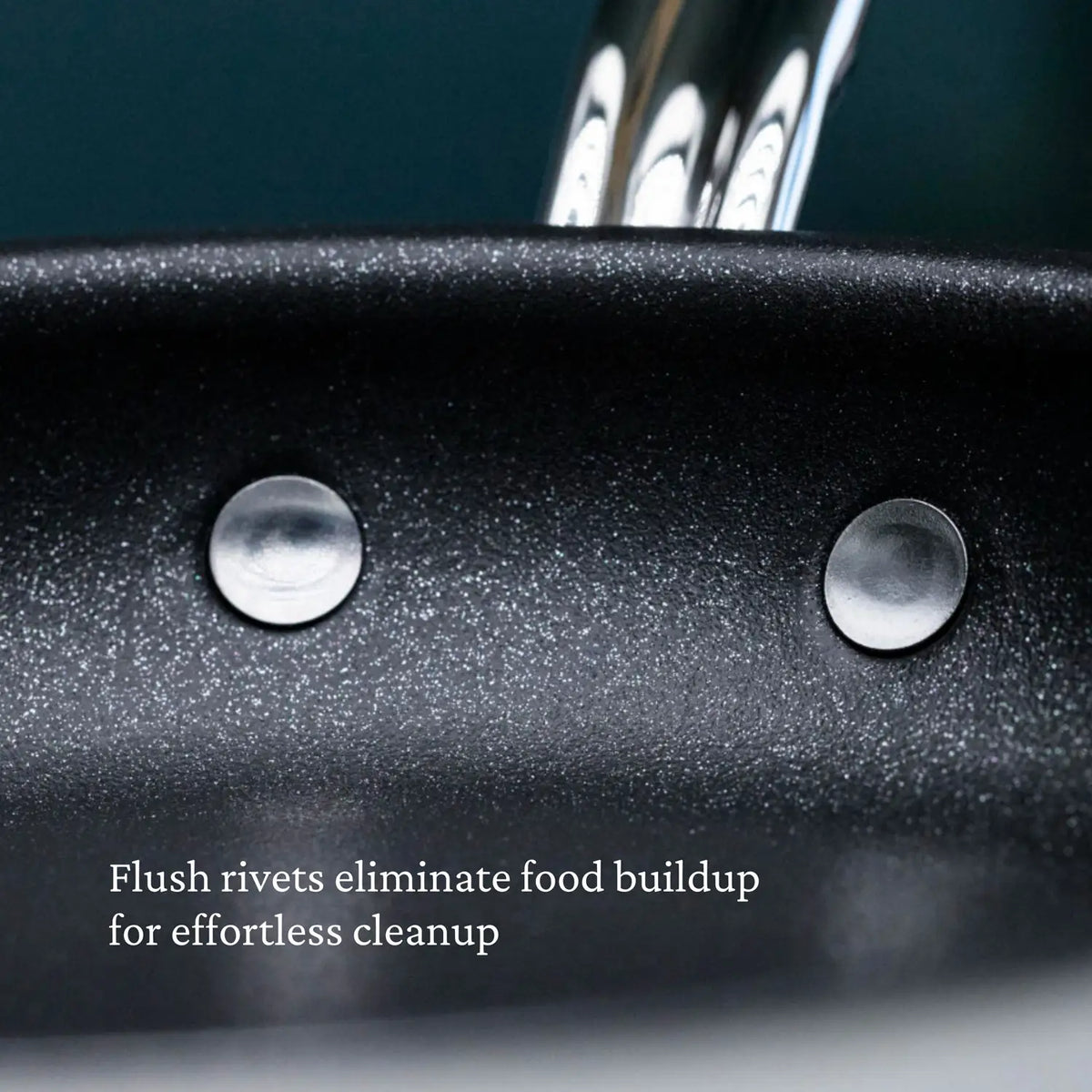Close-up of ProBond® Forged™ Brushed Clad Stainless Steel TITUM® Nonstick Skillet interior with two flush rivets. Text reads, “Flush rivets eliminate food buildup for effortless cleanup.”.