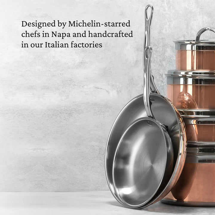 Two stainless steel frying pans sit on a light surface next to the CopperBond Copper Induction Braiser with Lid, 3.5-Quart. Text overlay: Designed by Michelin-starred chefs in Napa and handcrafted in our Italian factories.