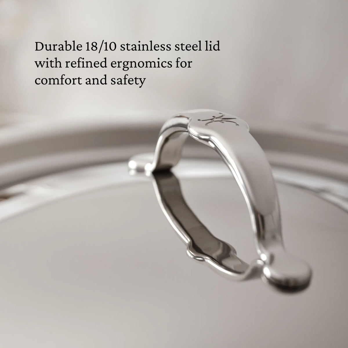 Close-up of the ProBond® Luxe™ Professional Clad Stainless Steel Soup Pot lid with a sturdy, curved handle, showcasing Italian craftsmanship. Overlaid text highlights durability and ergonomic design for comfort and safety.