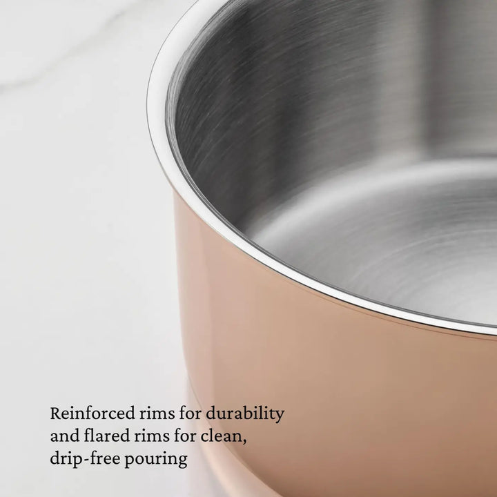 A close-up of a metal pot with a polished copper exterior, part of the CopperBond® Aura™ Polished Copper 10-Piece Cookware Set, highlighting its reinforced rim. Text on the image reads: Reinforced rims for durability and flared rims for clean, drip-free pouring.