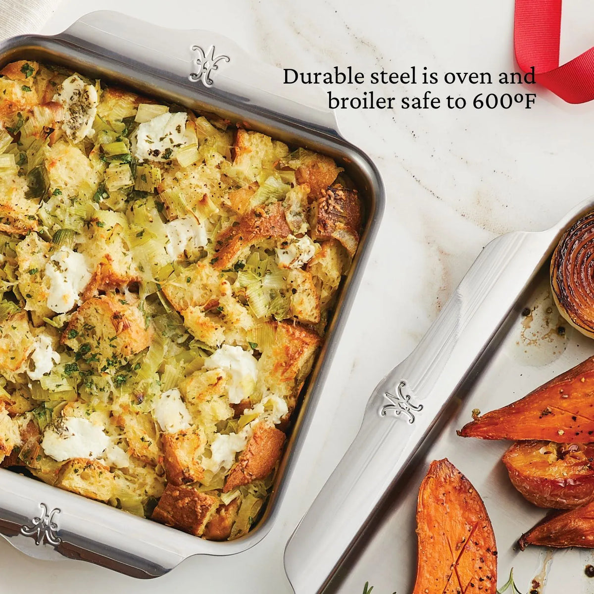 A Hestan OvenBond Tri-ply Square Baker with baked bread and veggie casserole is on a white surface by roasted sweet potatoes and onion. Text: Hestan OvenBond is oven and broiler safe up to 600°F.
