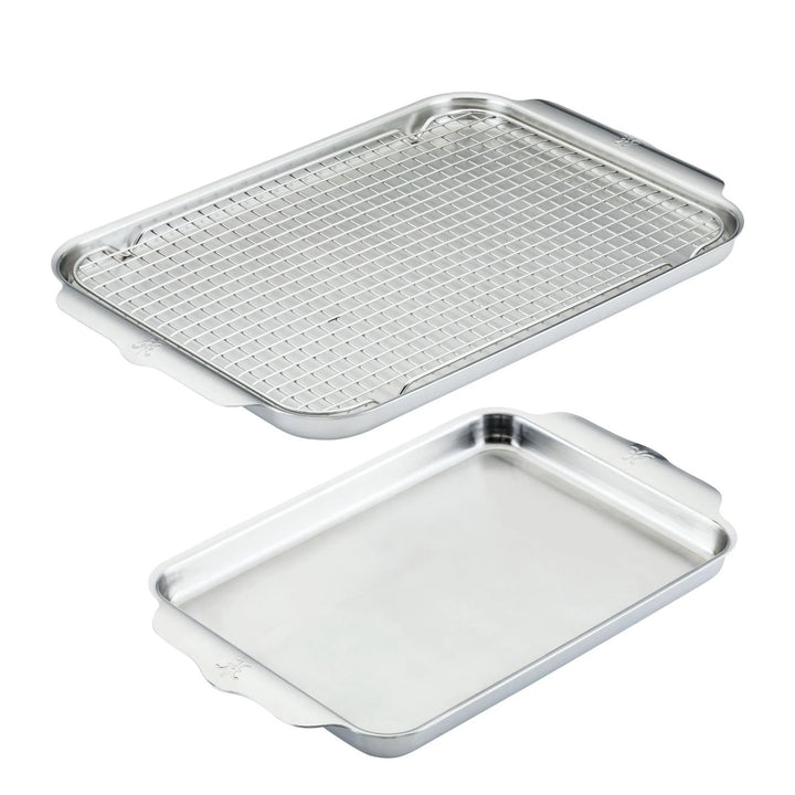 The Hestan OvenBond Tri-ply 3-Piece Set is shown, featuring a stainless steel sheet pan with sturdy side handles and a matching rack that fits inside—making it a perfect ovenware addition.