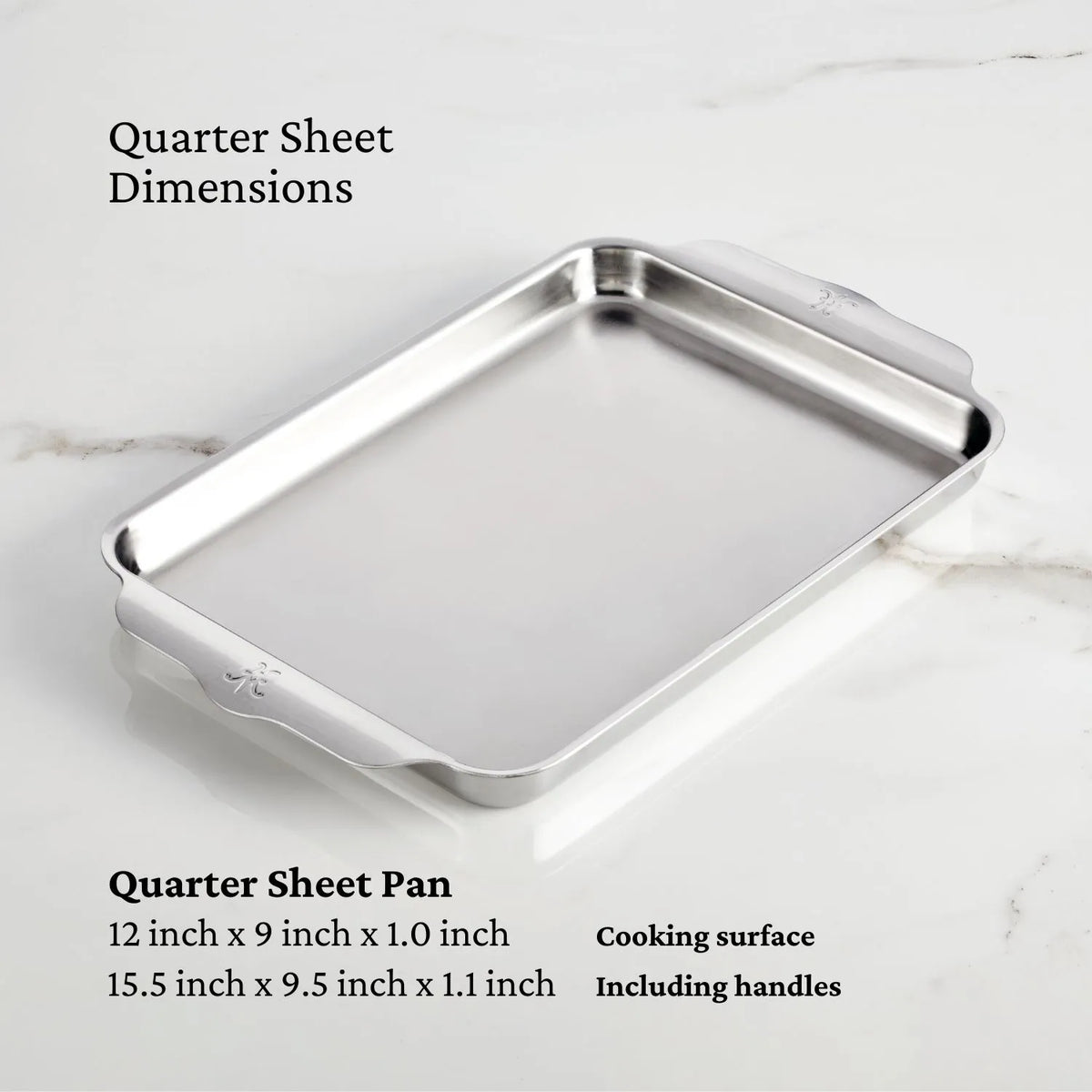 A Hestan OvenBond Tri-ply 3-Piece Set quarter sheet pan rests on white marble. Its cooking surface is 12 x 9 x 1 in, with full dimensions including handles of 15.5 x 9.5 x 1.1 in.