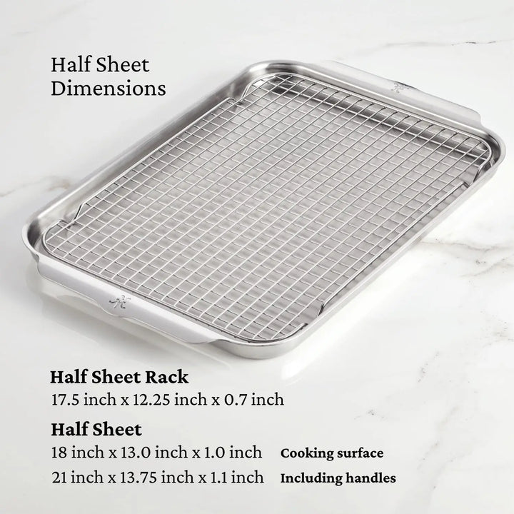 The Hestan OvenBond Tri-ply 5-Piece Set, made of durable stainless steel, sits on a marble countertop. This oven-safe bakeware includes both rack and pan with listed dimensions for handles and cooking surface.