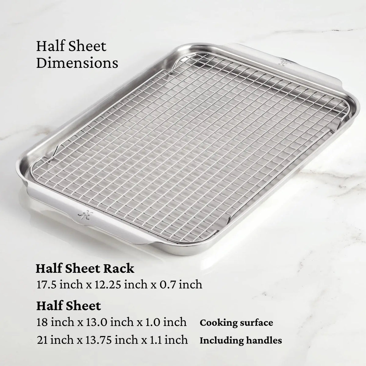 The Hestan OvenBond Tri-ply 5-Piece Set, made of durable stainless steel, sits on a marble countertop. This oven-safe bakeware includes both rack and pan with listed dimensions for handles and cooking surface.