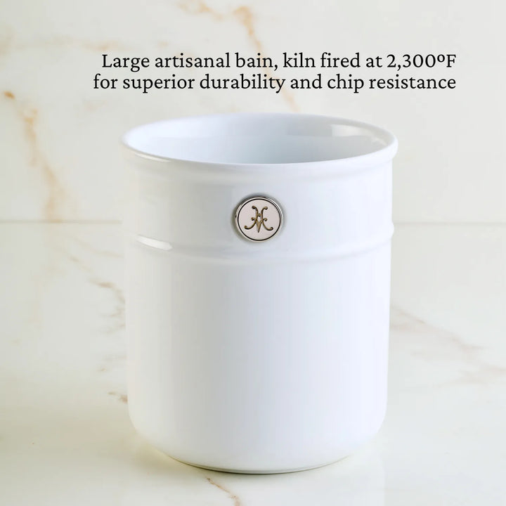 A white ceramic container sits on marble, featuring a small circular logo. Text above: Large artisanal bain, kiln fired at 2,300°F for exceptional durability and chip resistance. Ideal for Michelin-starred chefs seeking top-tier quality in Hestan Provisions Ultimate Chefs Tool Set, 8-piece.