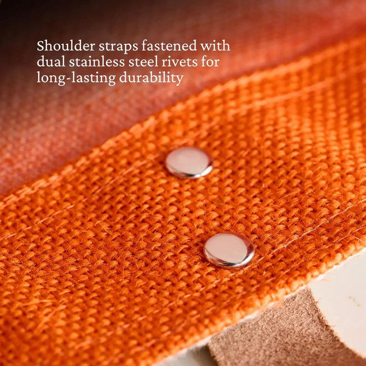 A close-up of Citra Orange fabric on the Accessories Hestan Market Tote features a strap secured by two stainless steel rivets, showcasing durable luxury and long-lasting quality.