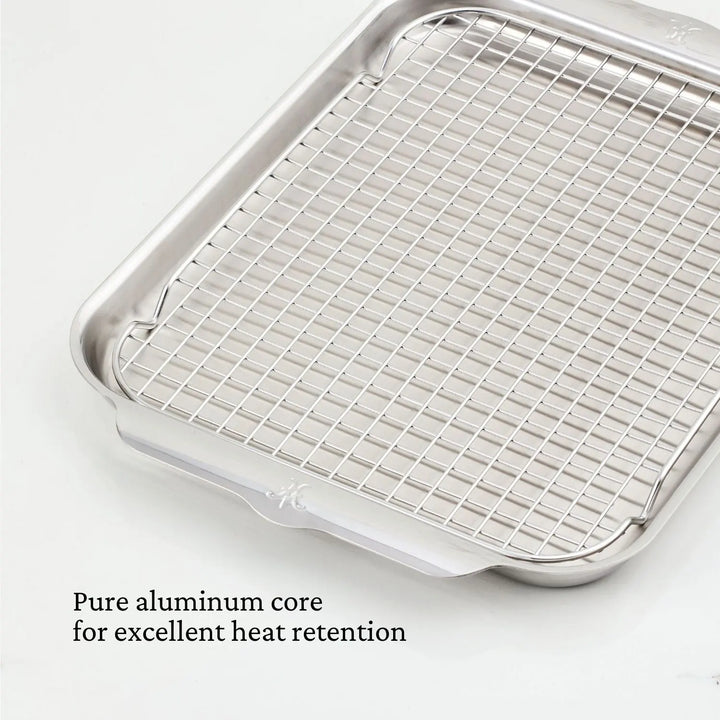 A Hestan OvenBond OvenBond Tri-Ply Medium Sheet Pan & Rack (12"x15") is shown on a white background. Text in the bottom left reads: Pure aluminum core for excellent heat retention.