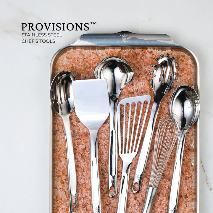 The Hestan Provisions Fine Mesh Skimmer, 16-inch, is displayed with serving tools on a tray of pink salt. Text reads: PROVISIONS STAINLESS STEEL CHEFS TOOLS.