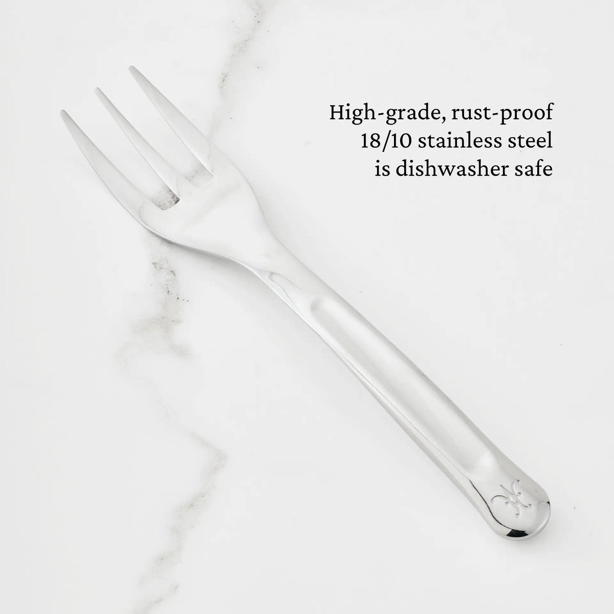 A 10.5-inch Stainless Steel Serving Fork from Hestan Provisions® rests on a white marble surface. Text beside it highlights that the fork is expertly crafted from high-grade, rust-proof 18/10 stainless steel and is dishwasher safe—making it an essential piece among the Hestan Provisions® Serving Tools and a must-have addition to any chef’s collection.