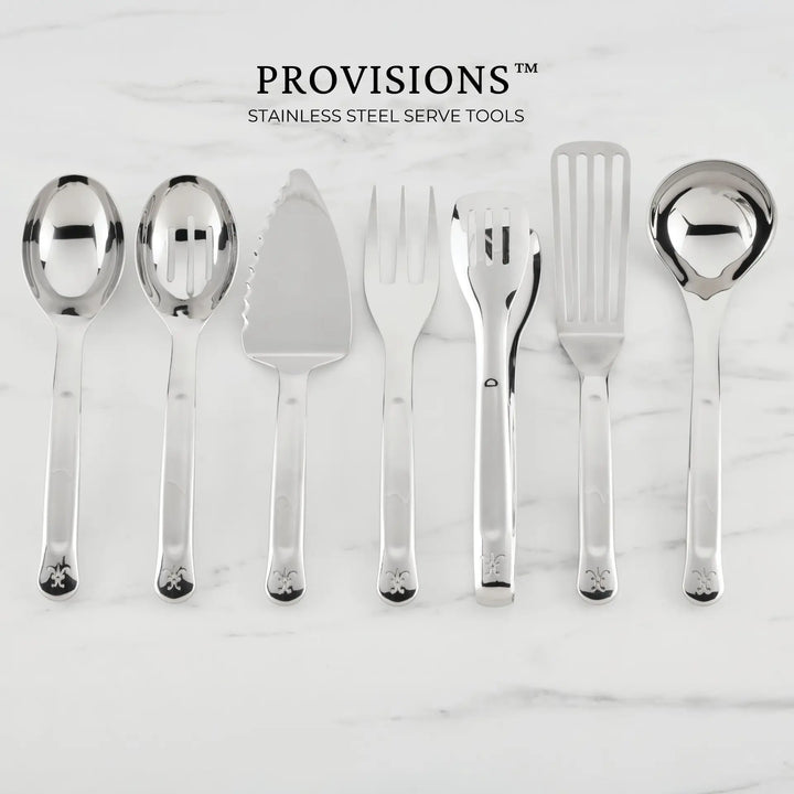 Seven Hestan Provisions® Serving Tools—including a serving spoon, slotted spoon, 10.5-inch Stainless Steel Pie & Cake Server, meat fork, salad tongs, slotted turner, and ladle—are arranged side by side on a white marble surface.