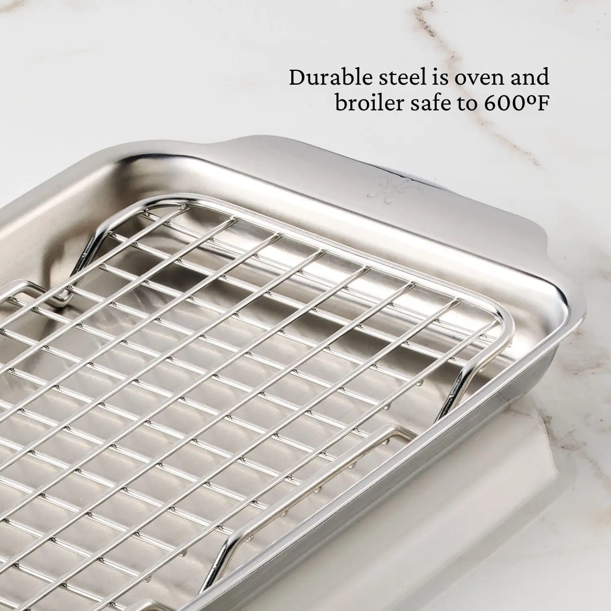 Hestan OvenBond Tri-ply Mini Eighth Sheet Pan with Rack shown on marble. Text: “Durable tri-ply steel is oven and broiler safe to 600°F.”.
