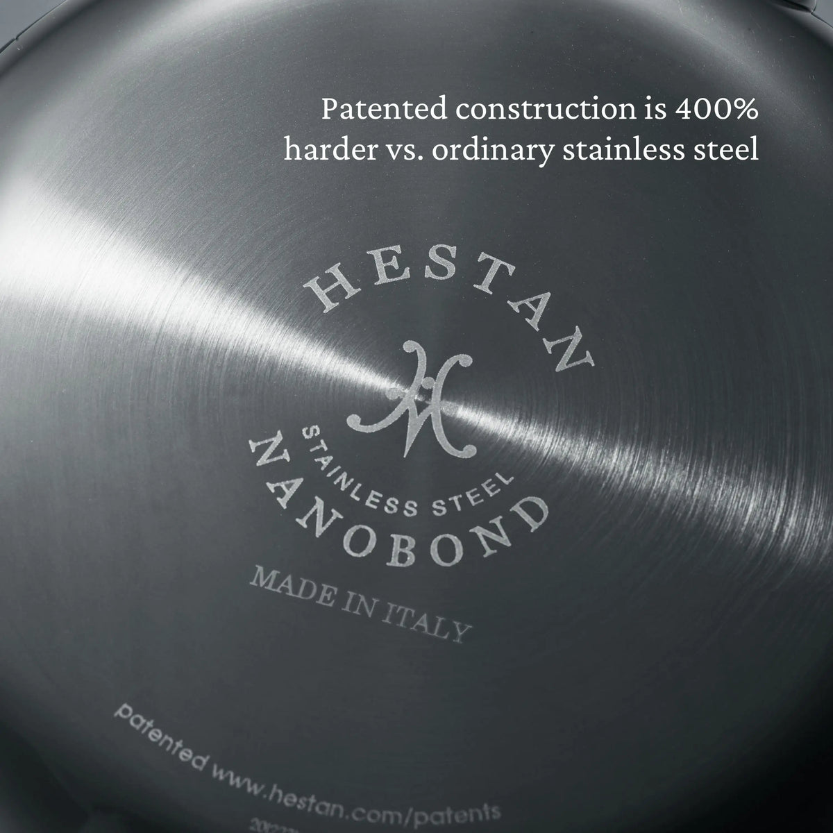 Close-up of the bottom of a NanoBond Titanium Rondeau with Lid, showing engraved branding. A label above notes its patented construction is 400% harder than ordinary stainless steel.