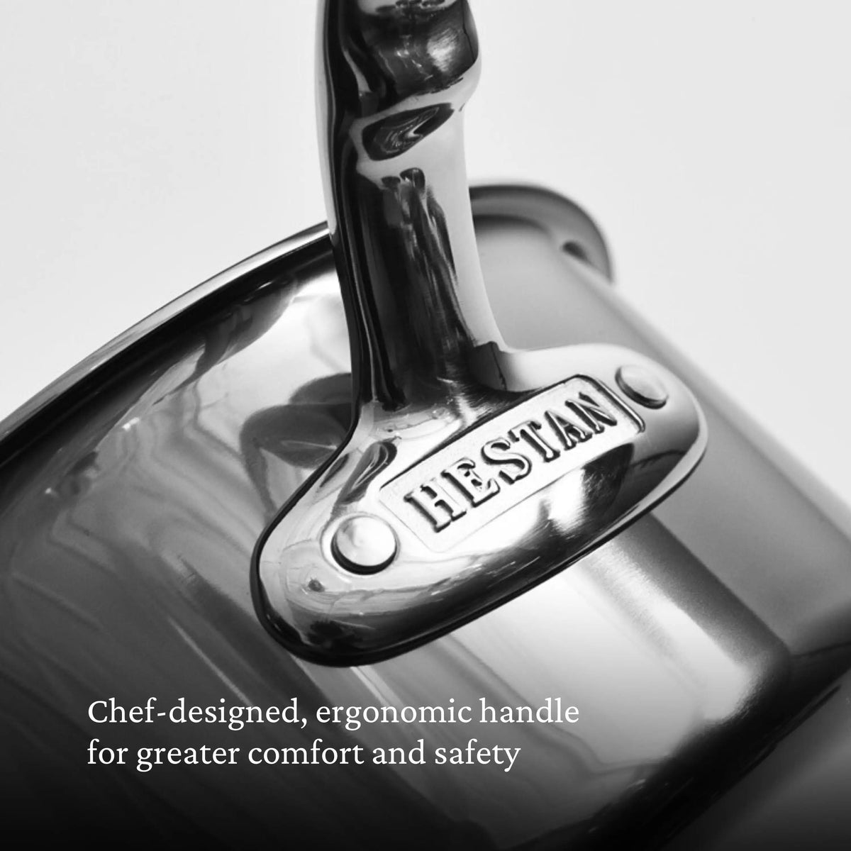 Close-up of a shiny metal handle engraved with NanoBond, highlighting the ergonomic design of the Titanium Rondeaus with Lids. Text below reads: Chef-designed, ergonomic handle for greater comfort and safety.