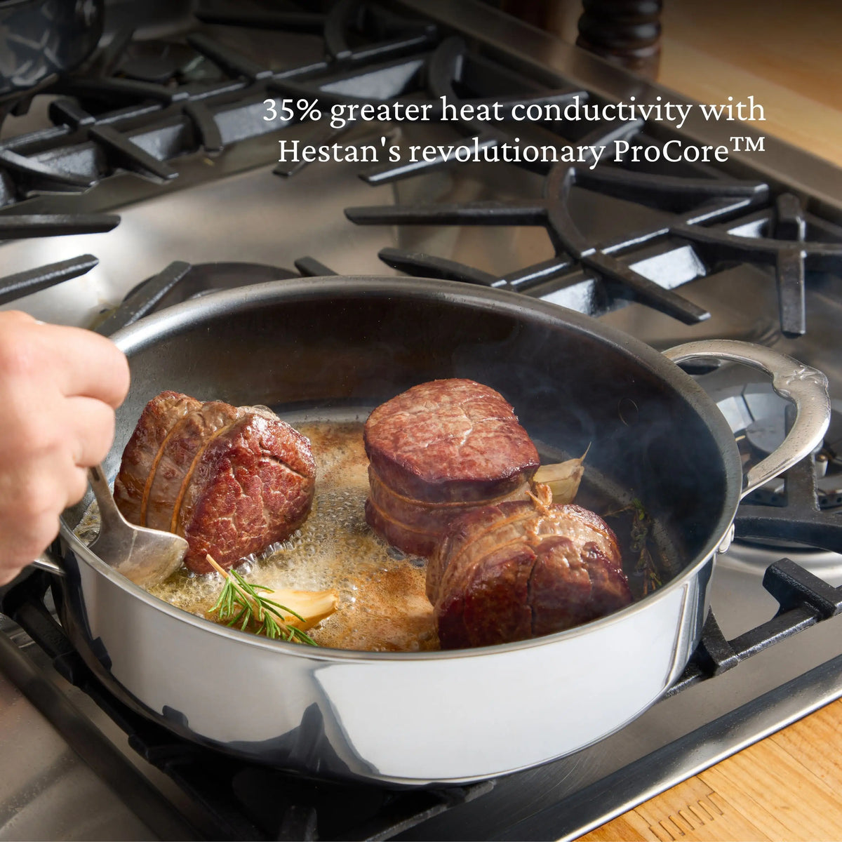 A hand sears three tied beef pieces in a NanoBond Titanium Rondeau with Lid on a gas stove. Text above the pan reads: “35% greater heat conductivity with NanoBond’s revolutionary ProCore™ technology.”.