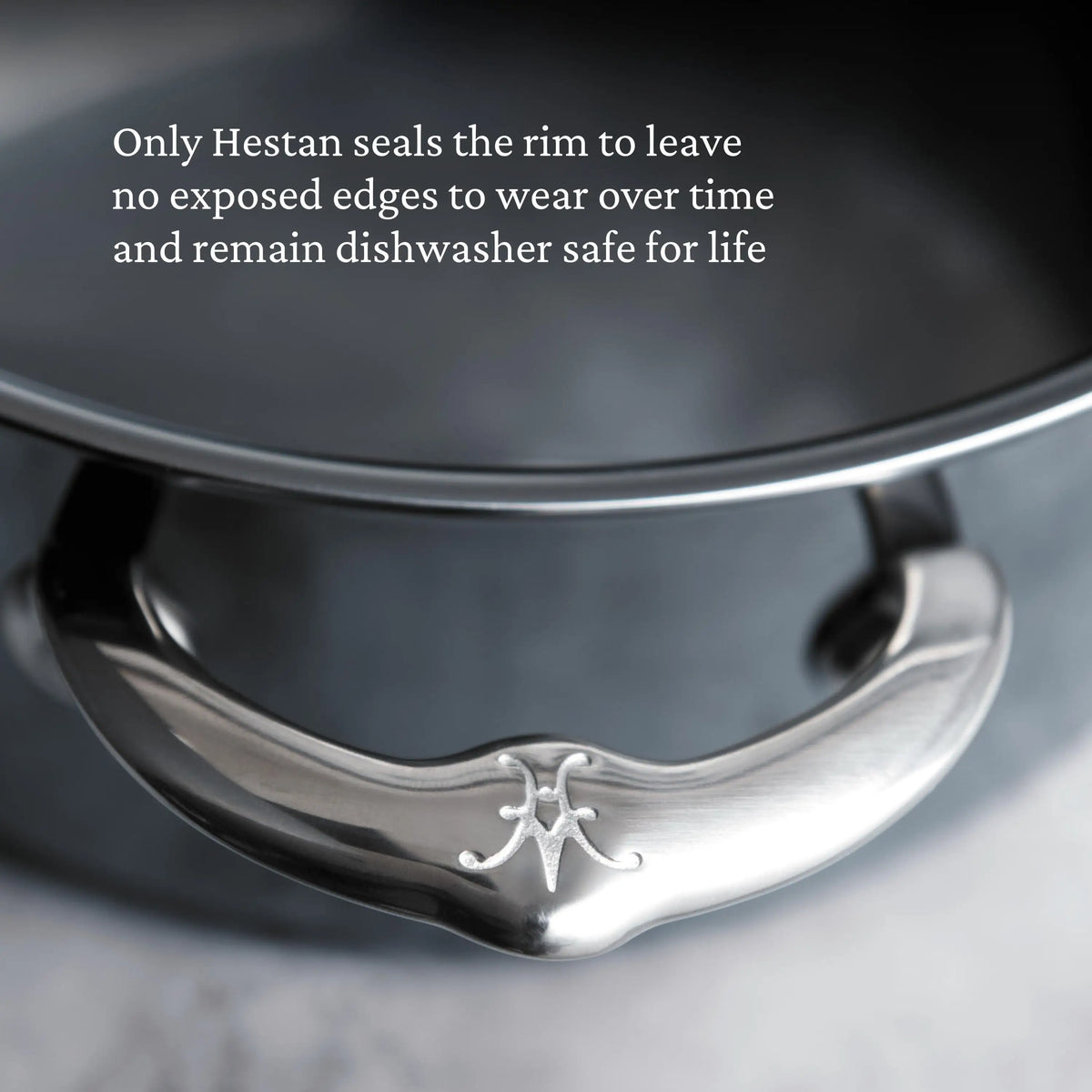 Close-up of a stainless steel handle with engraved logo. Text: “Only NanoBond Titanium Rondeaus with Lids seal the rim—no exposed edges to wear, and they stay dishwasher safe for life.”.