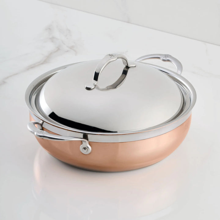 The CopperBond Copper Induction Dutch Oven, 5-Quart, with two handles and matching lid, is shown on a white marble surface, combining induction compatibility with timeless style.