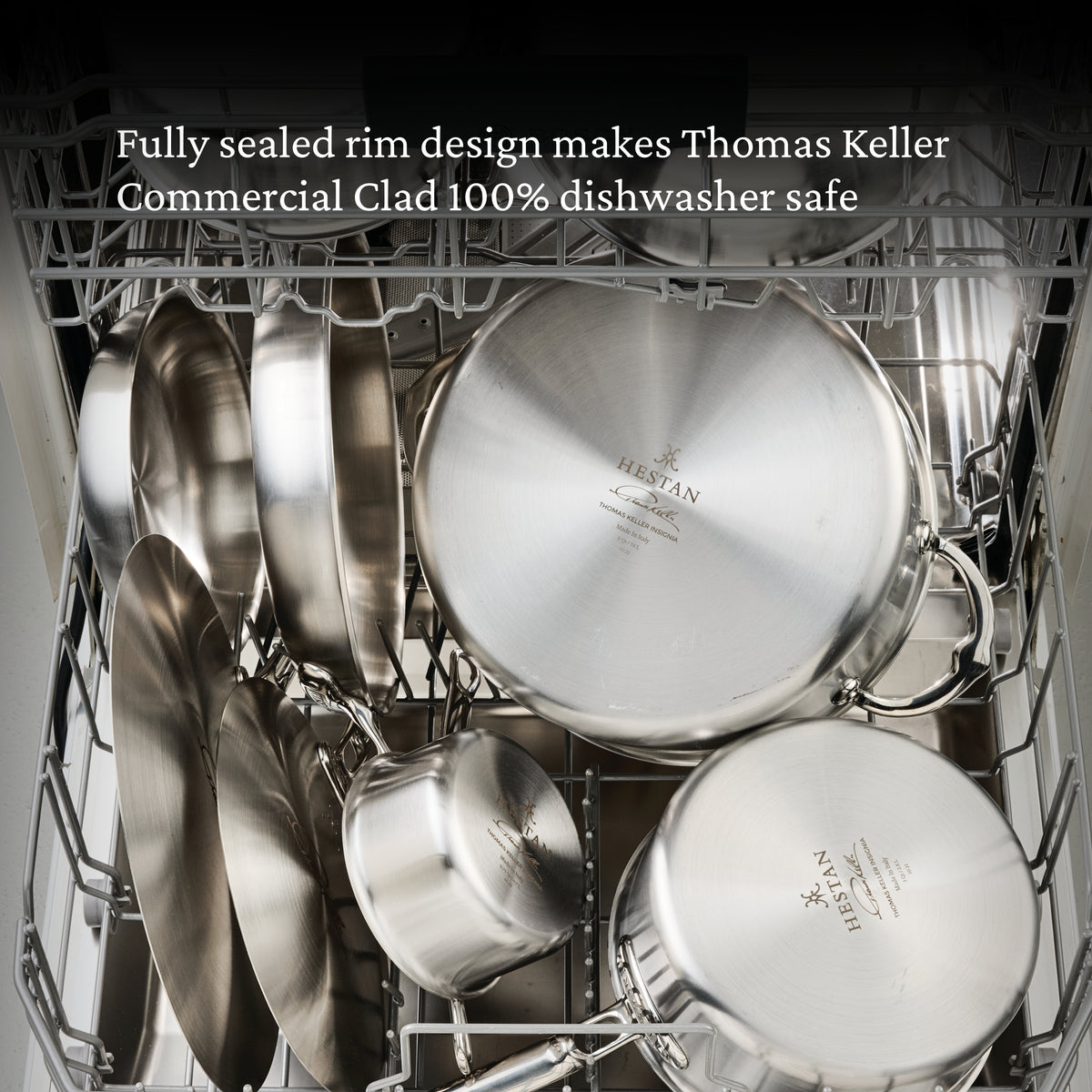 Several pieces from the Thomas Keller Commercial Clad Stainless Steel 11-Piece Cookware Set are arranged in a dishwasher. A message above notes: Fully sealed rim design makes this cookware 100% dishwasher safe.