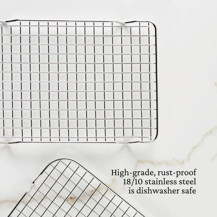 Two OvenBond Tri-ply Epicurean stainless steel cooling racks from Hestan Provisions are displayed on a white surface, highlighting their grid pattern with text stating, Durable, rust-proof 18/10 stainless steel bakeware thats dishwasher safe.