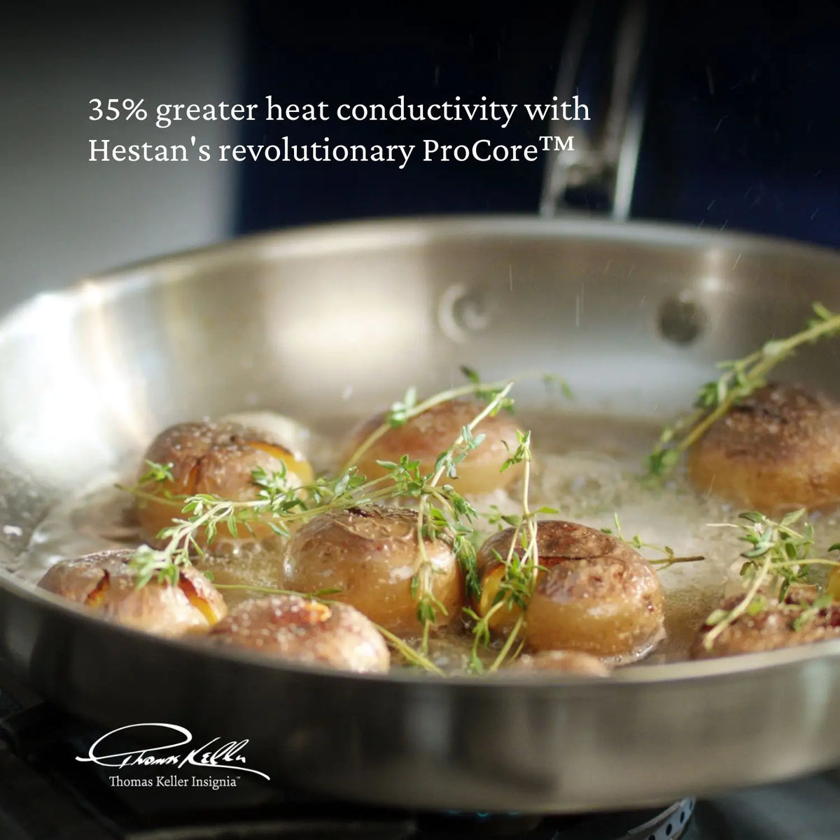 A stainless steel pan with round potatoes and thyme cooking in oil on a stovetop. Text reads, Get 35% greater heat conductivity with the Thomas Keller Commercial Clad Stainless Steel 10-Piece Cookware Set.