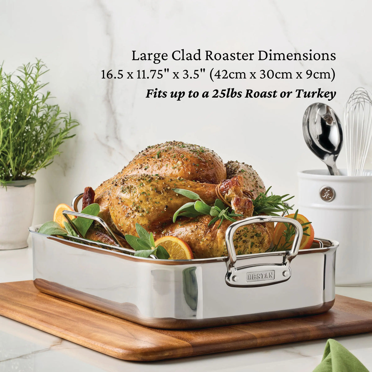 A succulent roasted turkey garnished with fresh herbs and citrus is elegantly presented in a spacious silver roasting pan atop a kitchen counter. The pan’s dimensions are provided, highlighting its generous capacity to hold up to a 25-pound roast or turkey—making it an ideal companion for your CopperBond® Copper Induction Set, 24-Piece.